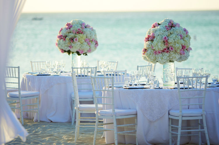 gorgeous Aruba beach wedding venue setup with white tables and flowers at Hilton Aruba